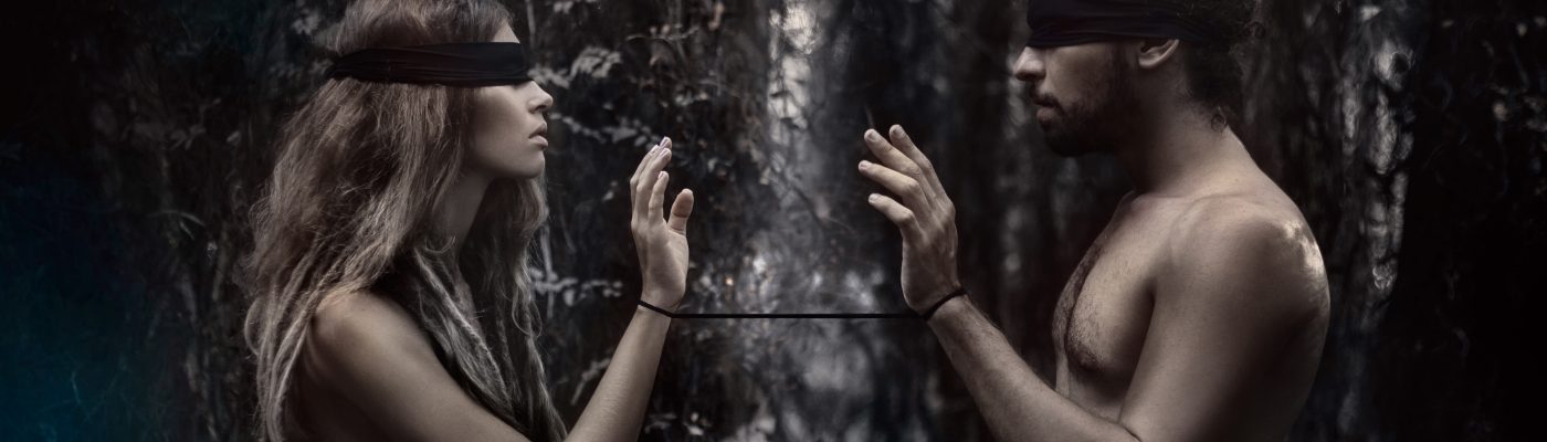 atrractive young man and woman with eyes closed. lost in forest